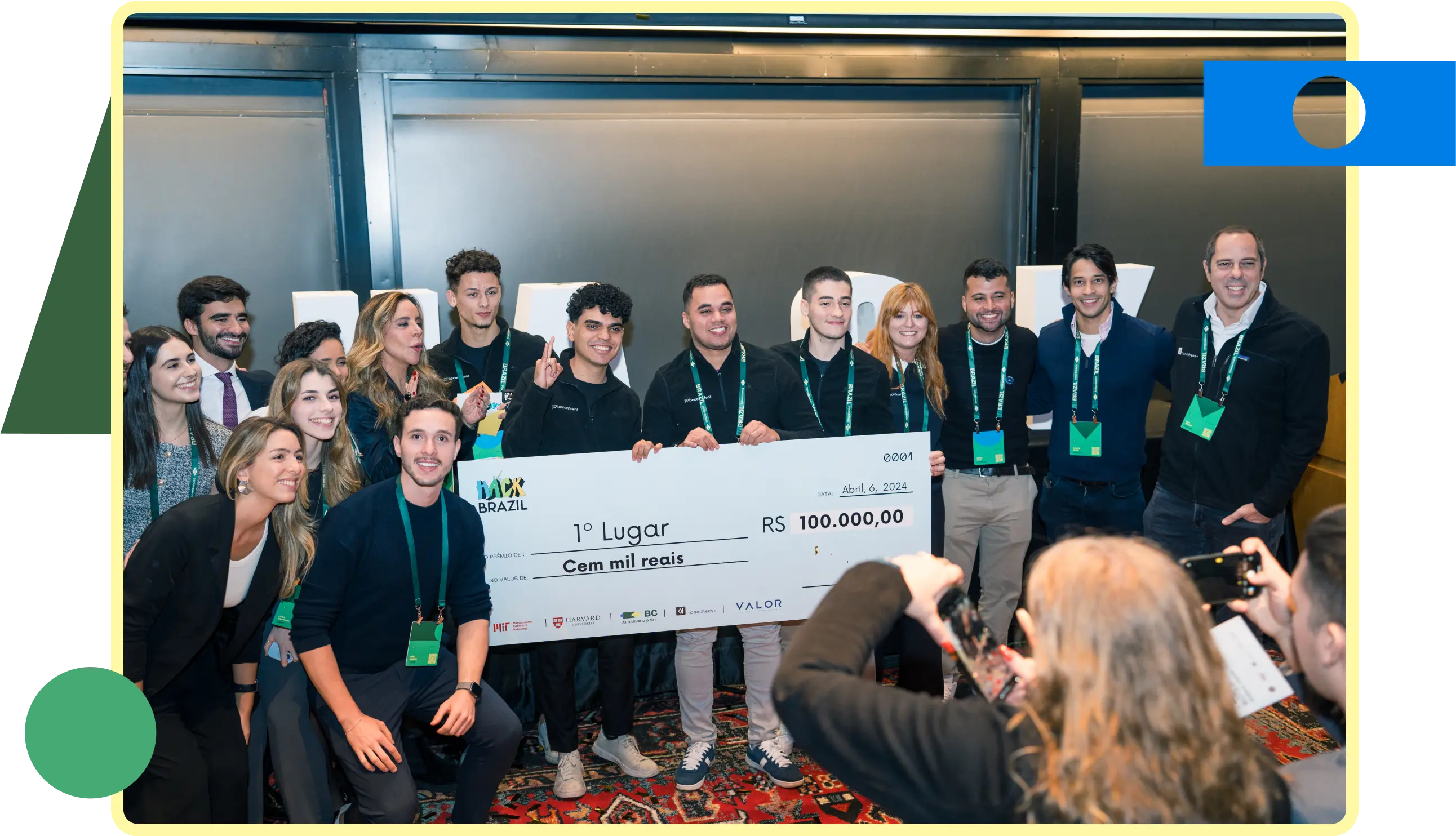 Um grupo de pessoas sorrindo e posando para a foto com um grande cheque nas mãos, celebrando uma conquista.